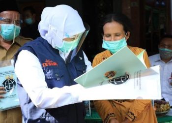 Gubernur Jatim Khofifah Indar Parawansa menyerahkan sertifikat tanah kepada warga yang.mengurus melalui program Pendaftaran Tanah Sistematis Lengkap (PTSL).
