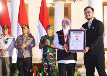 Gubernur Jawa Timur Khofifah Indar Parawansa menerima piagam penghargaan dari MURI yang diserahkan oleh Customer Relation Manager Museum Rekor Dunia Indonesia, Lutfi Syah Pradana.