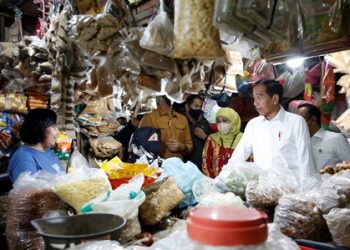 Presiden Joko Widodo berdialog dengan pedagang mengecek harga bahan pokok di Pasar Wonokromo, Surabaya.