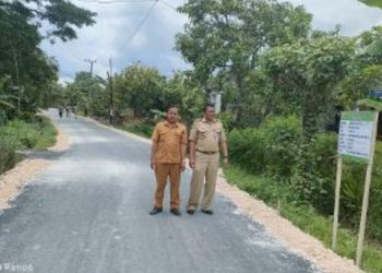 Kades Duwel Ahmad Rifa'iberdiri di atas jalan poros yang sudah selesai dilakukan pengaspalan.