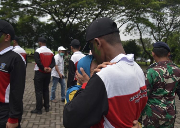 Suliah tak kuasa menahan tangis sambil memeluk anaknya, Rasyid, pada penutupan sekolah kebangsaan angkatan pertama.
