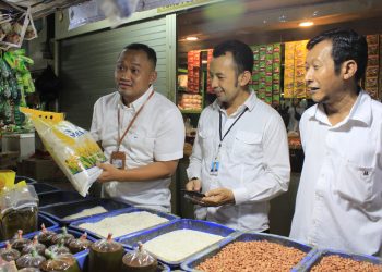 Direktur Utama PD Pasar Surya Agus Priyo (kiri) bersama Direktur Keuangan Sutjahjo (tengah) berdialog dengan pedagang di Pasar Wonokromo di sela operasi pasar komoditi beras di pasar tersebut.