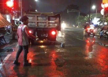 Petugas dari Dinas Sumber Daya Air dan Bina Marga (DSDABM) melakukan pemeliharaan jalan di Kota Pahlawan.