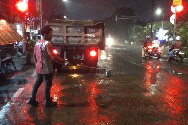 Petugas dari Dinas Sumber Daya Air dan Bina Marga (DSDABM) melakukan pemeliharaan jalan di Kota Pahlawan.