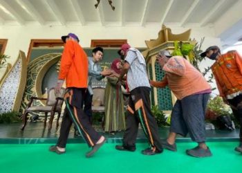 Gubernur Jatim Khofifah Indar Parawansa bersama sang putra kedua Jalaluddin menyalami warga yang menghadiri open house di gedung negara Grahadi.