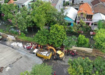 Tim dari Pemkot Surabaya dikerahkan untuk mengatasi jebolnya pelapis tanggul di kawasan Kembang Kuning yang menjadi penyebab banjir di Jalan Mayjen Sungkono.