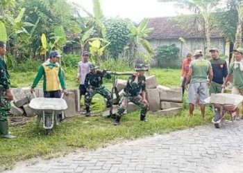 Babinsa Koramil 09/Sumberrejo, Kodim 0813 Bojonegoro melaksanakan karya bakti memperbaiki jalan di RT 013/RW 003 Desa Karangdowo.