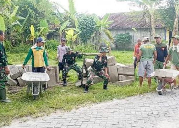 Babinsa Koramil 09/Sumberrejo, Kodim 0813 Bojonegoro melaksanakan karya bakti memperbaiki jalan di RT 013/RW 003 Desa Karangdowo.