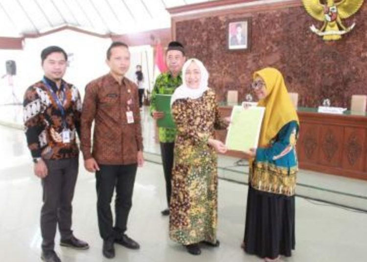 Bupati Bojonegoro Anna Mu'awanah menyerahkan surat keputusan (SK) pensiun kepada salah satu pegawai negeri sipil yang sudah purna tugas.