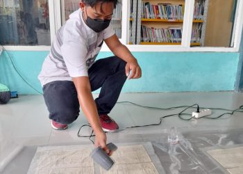 Seorang petugas sedang melaksanakan tahapan restorasi arsip yang memerlukan ketelitian dan ketelatenan.