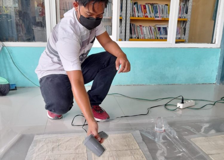 Seorang petugas sedang melaksanakan tahapan restorasi arsip yang memerlukan ketelitian dan ketelatenan.