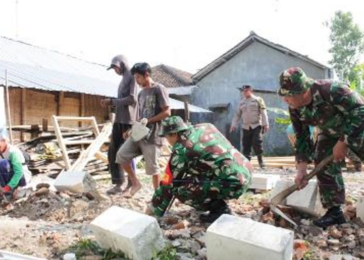 Personel Koramil 09/Sumberrejo, Kodim 0813 Bojonegoro melakukan kegiatan karya bakti pembangunan rumah tinggal layak huni.