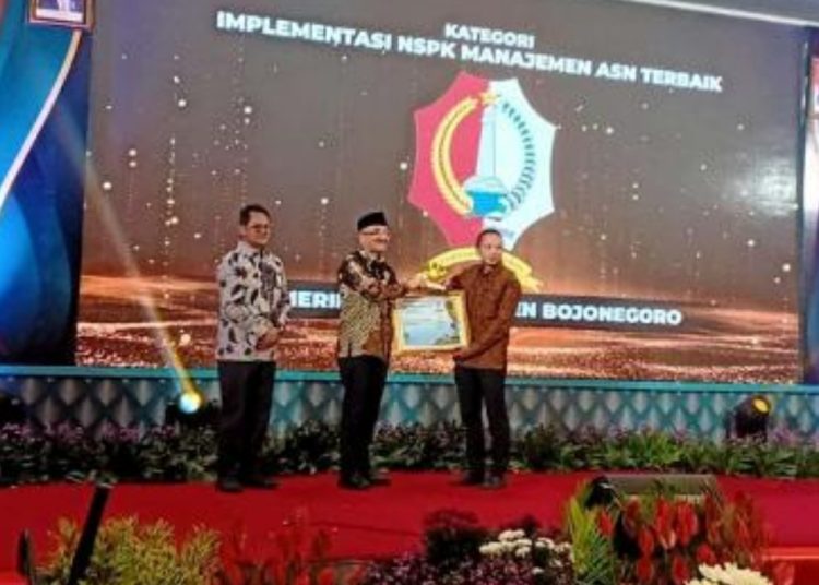 Plt Kepala Badan Kepegawaian Negara Bima Haria Wibisana menyerahkan penghargaan kepada Pemkab Bojonegoro yang diwakili oleh Kepala Badan Kepegawaian, Pendidikan dan Pelatihan (BKPP) Kabupaten Bojonegoro Aan Syahbana.