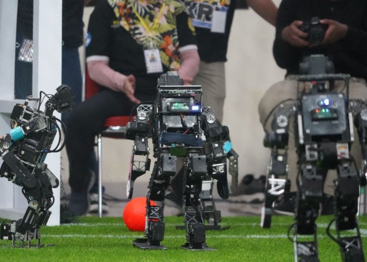 Robot Tim Ichiro saat hendak mencetak gol ke kandang lawan pada kategori Kontes Robot Sepak Bola Indonesia-Humanoid di ajang Kontes Robot Indonesia (KRI) 2023.