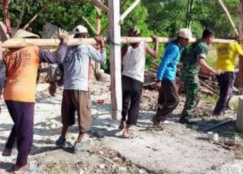 Babinsa Koramil 09/Sumberrejo Peltu Agus Suyanto bersama mahasiswa KKN dari Universitas Brawijaya dan masyarakat melaksanakan karya bakti perbaikan rumah warga.