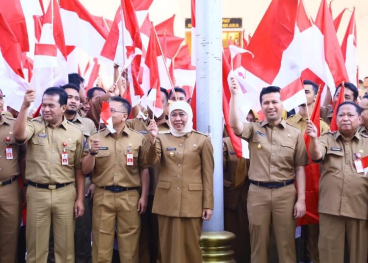 Gubernur Jatim Khofifah Indar Parawansa bersama Wagub Jatim Emil Elestianto Dardak mengibarkan merah putih pada apel pagi di halaman kantor Sekretariat Daerah Provinsi Jatim, Surabaya.