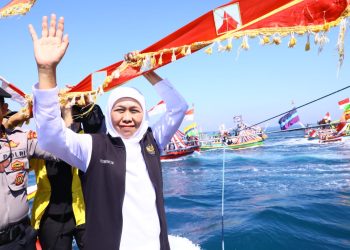 Gubernur Jawa Timur Khofifah Indar Parawansa sedang mengikuti acara tradisi Petik Laut bersama ribuan warga lainnya.