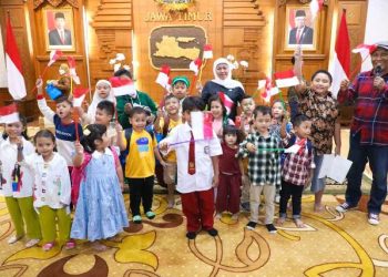 Anak-anak yang terpantau memberikan hormat saat mengikuti upacara peringatan HUT ke 78 RI diundang ke gedung Negara Grahadi.