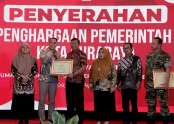 Wali Kota Surabaya Eri Cahyadi menyerahkan penghargaan disaksikan pimpinan DPRD Surabaya.