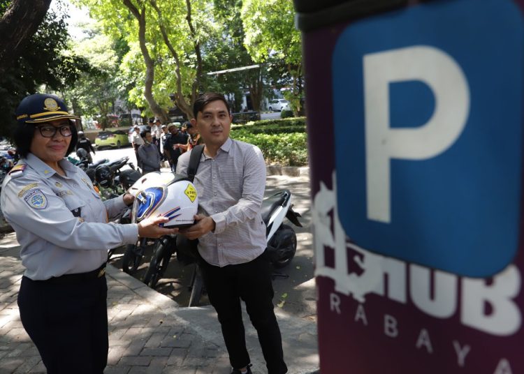 Personel Dinas Perhubungan (Dishub) Surabaya menggelar sosialisasi gerakan minta karcis parkir dan bagi-bagi helm.