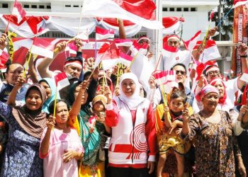 Gubernur Jawa Timur Khofifah Indar Parawansa di sela pembagian bendera merah putih dan sembako kepada masyarakat.
