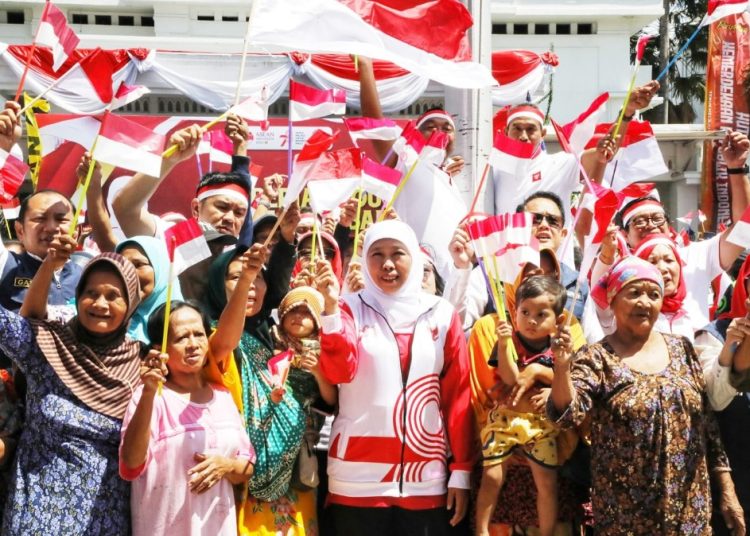 Gubernur Jawa Timur Khofifah Indar Parawansa di sela pembagian bendera merah putih dan sembako kepada masyarakat.