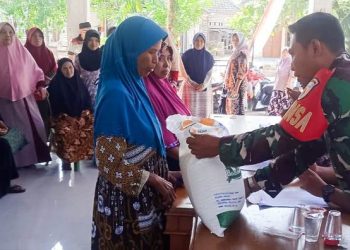 Babinsa Koramil 09/Sumberrejo Kodim 0813 Bojonegoro, Serda Endro Widodo, dalam kegiatan pendistribusian bantuan sosial pangan Cadangan Beras Pemerintah (CBP) tahun 2023.