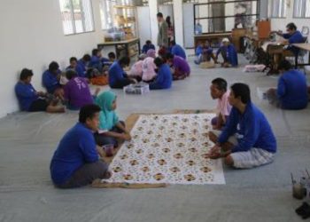 Para penghuni UPTD Liponsos Keputih diajari membatik.