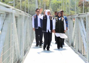 Gubernur Jawa Timur Khofifah Indar Parawansa bersama rombongan melewati jembatan gantung Kaliregoyo di Desa Sumberwuluh, Kecamatan Candipuro, Lumajang.