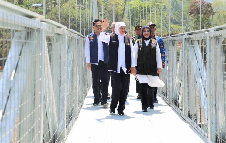 Gubernur Jawa Timur Khofifah Indar Parawansa bersama rombongan melewati jembatan gantung Kaliregoyo di Desa Sumberwuluh, Kecamatan Candipuro, Lumajang.