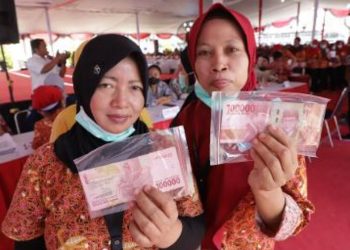 Dua buruh pabrik menerima Bantuan Langsung Tunai dari Dana Bagi Hasil Cukai Tembakau.