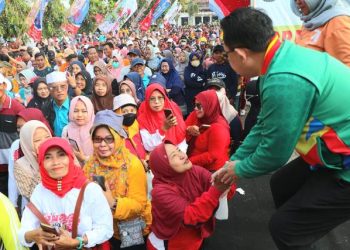 Sekdaprov Jatim Adhy Karyono menyalami peserta jalan sehat di halaman Bakorwil Pamekasan.