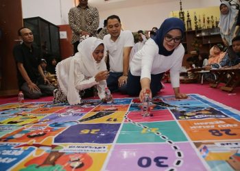 Ketua TP PKK Surabaya Rini Indriyani bermain dengan salah satu anak saat meninjau pelaksanaan KAS-RPA di Balai RW 05 Kelurahan Balongsari, Kecamatan Tandes.
