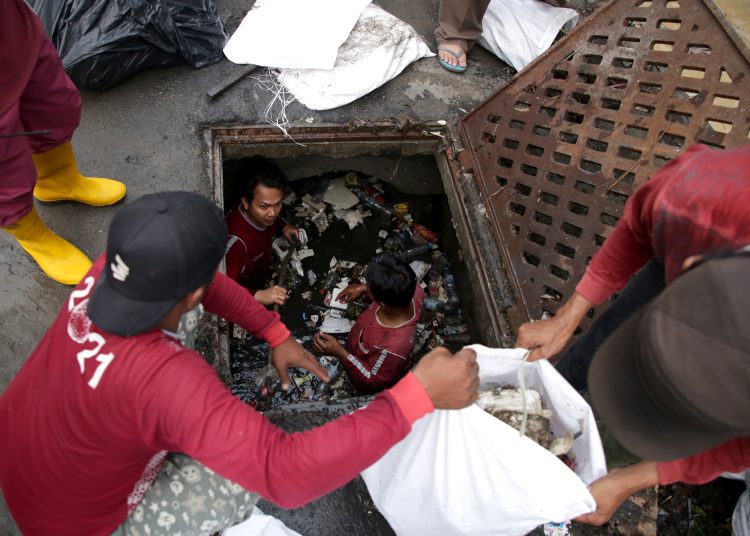 Personel Dinas Sumber Daya Air dan Bina Marga Surabaya melakukan pengerukan saluran di kawasan Dukuh Kupang, Kecamatan Sawahan.
