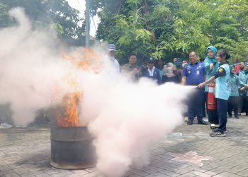Simulasi pemadaman api dilakukan untuk menyambut kehadiran Tim Penilai Observasi Lapangan Pilot Project Gerakan Keluarga Sehat Tanggap dan Tangguh Bencana di Kelurahan Wonorejo, Rungkut, Surabaya.