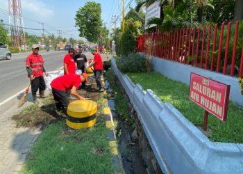 Karyawan Coca-Cola Europacific Partners Indonesia membersihkan lingkungan sekitar pabriknya di Jalan Raya Surabaya-Malang Desa Kepulungan Kecamatan Gempol, Pasuruan.