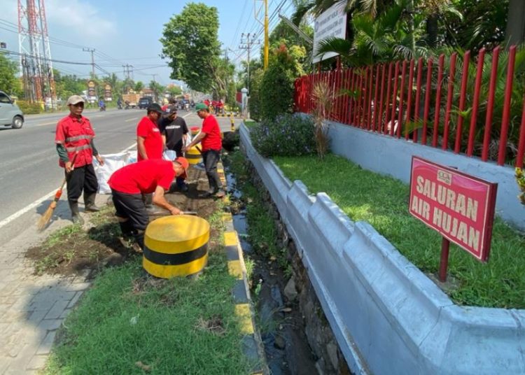 Karyawan Coca-Cola Europacific Partners Indonesia membersihkan lingkungan sekitar pabriknya di Jalan Raya Surabaya-Malang Desa Kepulungan Kecamatan Gempol, Pasuruan.