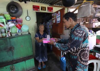 Foto ilustrasi pemberian makanan dalam program permakanan oleh Pemkot Surabaya.