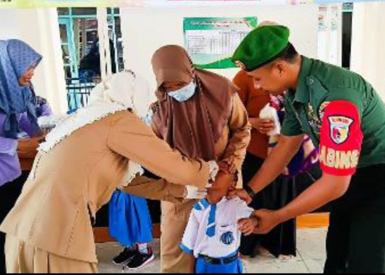 Babinsa Kodim Bojonegoro melakukan pendampingan imunisasi polio.