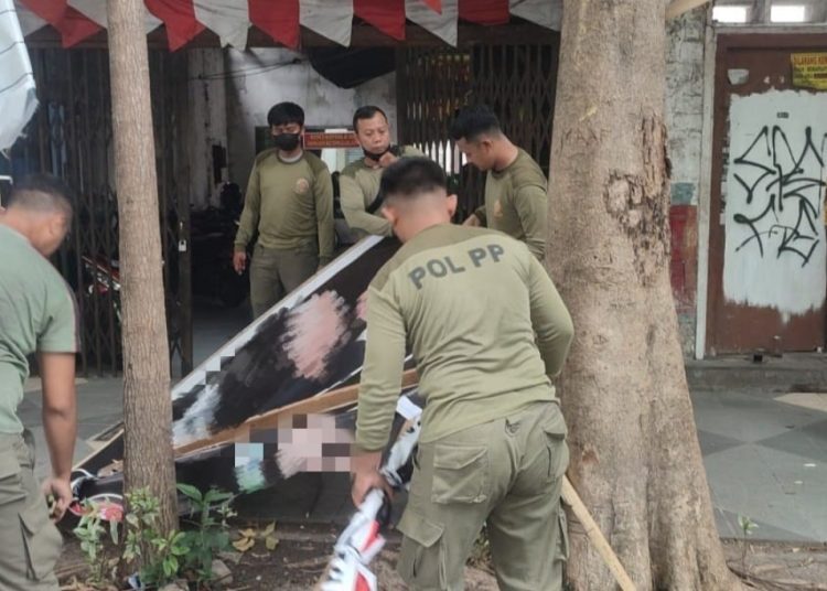 Penertiban alat peraga kampanye yang dilakukan di salah satu lokasi di Surabaya.