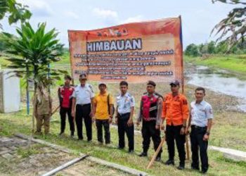 Pemasang banner imbauan risiko beraktivitas di perairan oleh BPBD Bojonegoro.