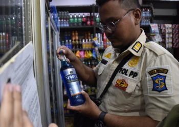 Personel Satpol PP Surabaya saat razia minuman beralkohol di toko kelontong.