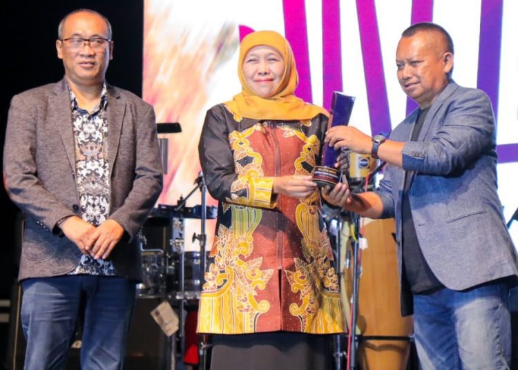 Gubernur Jatim Khofifah Indar Parawansa saat menerima penghargaan dari Ketua PWI Jatim Lutfil Hakim.