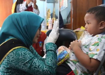 Ketua Tim Penggerak  PKK Surabaya Rini Indriyani bercengkerama dengan anak saat meninjau mengunjungi pelaksanaan Sub PIN Polio di Posyandu Rosella di Balai RW 10, Kelurahan Ploso Timur, Kecamatan Tambaksari. 