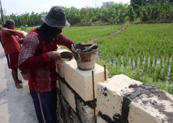 Pengerjaan tanggul di Jalan Tengger Raya, Sambikerep, Surabaya.