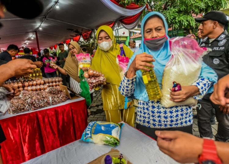 Warga berbelanja di salah satu lokasi pasar murah yang digelar serentak di 31 kecamatan se-Surabaya.