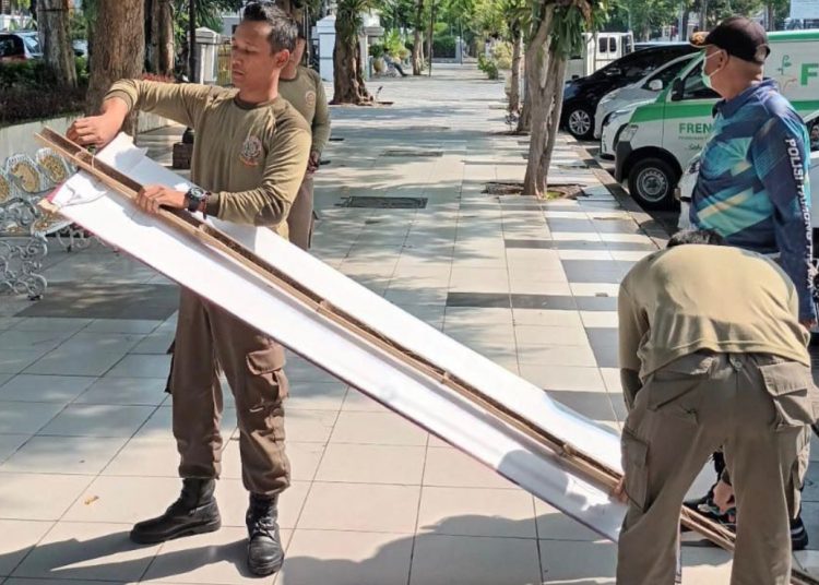 Penertiban reklame oleh personel Satpol PP Surabaya.