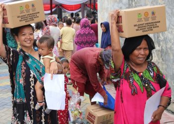 Warga menerima paket sembako yang dibagikan Pemkot Surabaya.