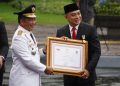 Mendagri Tito Karnavian menyerahkan penghargaan menerima penghargaan Penyelenggaraan Pemerintah Daerah Berkinerja Tinggi kepada Wali Kota Surabaya Eri Cahyadi.