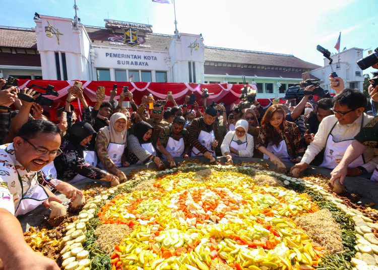 Wali Kota Surabaya Eri Cahyadi dan Wakil Wali Kota Surabaya Armuji ngulek rujak bareng di cobek raksasa pada Festival Rujak Uleg di halaman Balai Kota Surabaya.